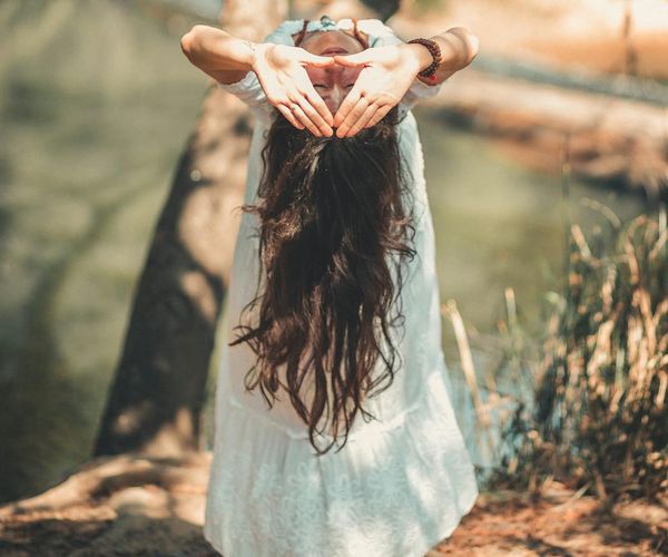 A person meditating in a peaceful natural environment.